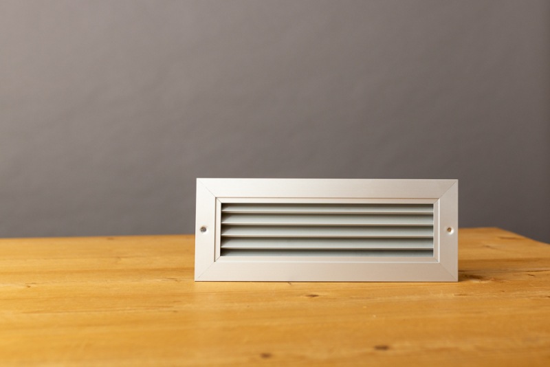 Aluminium deurrooster 450x100mm met tegenkader en schroefgaten in de flens