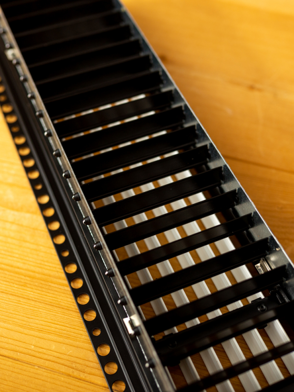 In stucbaar frameloos wandrooster 800x150mm met een vaste lamel aan de voorkant en instelbare aan de achterkant - Zwarte achterkant 
